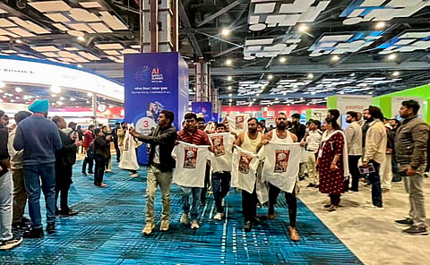 In this image received on February 20, 2026, Indian Youth Congress (IYC) workers stage a 'shirtless protest', walking around holding T-shirts with slogans against the government and the India-US trade deal printed on them, at the AI Impact Summit, in New Delhi.