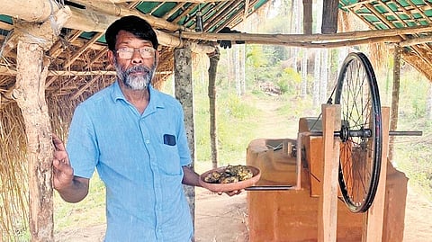 Ajayan Chekadi near the natural grill made with clay and cycle wheel.