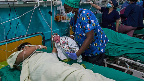 A doctor hands a newborn baby to its mother at the Ramón González Coro Maternity Hospital in Havana, Cuba, Friday, Feb. 20, 2026.