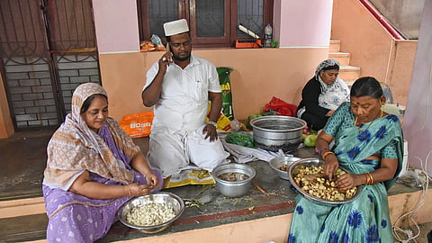 M Mydeen Abdul Khader with his family members and neighbor Rajeswari preparing Ramzon Sahar food to distribute college students for free in Tiruchy on Friday.