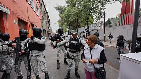National Guards remove a pedestrian around the General Prosecutor's headquarters in Mexico City, Sunday, Feb. 22, 2026, after the death of the leader of the Jalisco New Generation Cartel, Nemesio Rubén Oseguera Cervantes, known as "El Mencho."