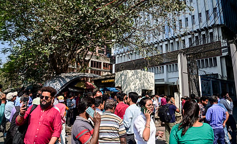 People gather outside Metro Rail Bhavan building as tremors were felt in the city and adjacent districts of West Bengal, in Kolkata, Friday, Feb. 27, 2026. An earthquake of 5.5 magnitude on the Richter Scale jolted parts of Bangladesh, officials said.
