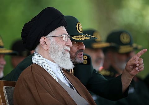 In this picture released by the official website of the office of the Iranian supreme leader, Supreme Leader Ayatollah Ali Khamenei listens to the then commander of the Revolutionary Guard Mohammad Ali Jafari