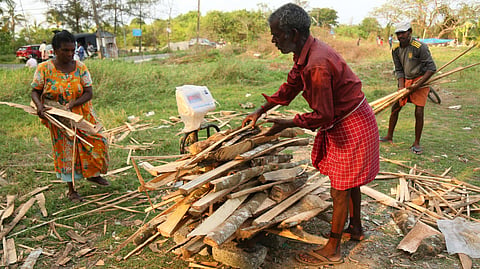 Workers weighing wood scraps for sale.