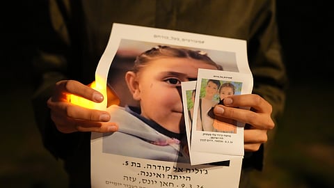 Activists stand with pictures of children killed in Israel, Palestinian territories, Iran and Lebanon in a silent vigil calling for an end to the war in Tel Aviv, Israel, Thursday, March 19, 2026.
