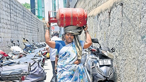 A woman carries a 15kg cylinder to her home in Bengaluru
on Monday