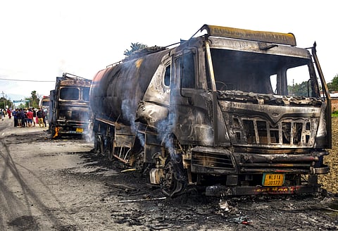 Charred remains of fuel tankers lie on a road after they were set ablaze by people in protest when two children were killed and their mother was injured in a bomb attack, in Bishnupur district, Manipur, Tuesday, April 7, 2026.