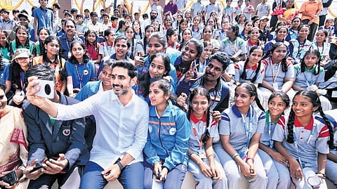 HRD and IT Minister Nara Lokesh takes a selfie with students after inaugurating sports infrastructure projects worth Rs 35 crore
in Tirupati on Wednesday.