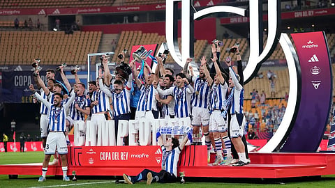 Real Sociedad's team players celebrate with the trophy after the Copa del Rey final soccer match between Atletico Madrid and Real Sociedad in Seville, Spain, Saturday, April. 18, 2026.