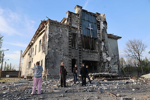 People stand outside a Baptist church damaged by a Russian guided aerial bomb, in Zaporizhzhia, Ukraine, Thursday, April 16, 2026.