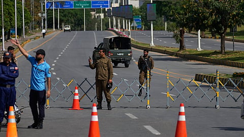 Police officers stand guard at a checkpoint ahead of the second round of negotiations between the U.S. and Iran, in Islamabad, Pakistan, Tuesday, April 21, 2026.