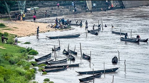 People fishing in the floodwaters of the Mahanadi at the Mundali barrage in Cuttack