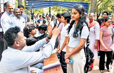 Higher Education Minister MC Sudhakar scans students who arrived for CET at a college in Bengaluru on Friday