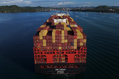 Cargo containers are stacked on a cargo ship moving through the Panama Canal, at sunrise in Panama City, Wednesday, March 25, 2026.
