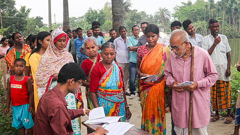 A poll official checks the names of the voters on a list