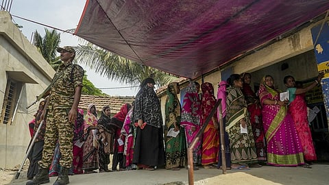 People wait in a queue to cast votes during the first phase of the West Bengal Assembly election.
