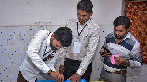 Polling officials are seen sealing an EVM after voting for the Gujarat local body polls, in Surat, Sunday, April 26, 2026.
