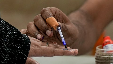 A polling official marks a voter's finger with indelible ink during the second and final phase of the West Bengal Assembly elections, at a polling station in Kolkata, Wednesday, April 29, 2026.