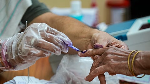 A polling official marks a voter's finger with indelible ink during the second and final phase of the West Bengal Assembly elections, at a polling station in Kolkata, Wednesday, April 29, 2026.