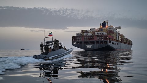 In this photo released by Tasnim News Agency, a Revolutionary Guard Navy (IRGC) speedboat approaches the cargo ship Epaminondas during what state media described as the seizure of one of two vessels accused of violations in the Strait of Hormuz, April 21, 2026.