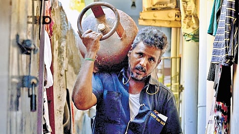 A staff delivering an LPG cylinder at Saidapet in Chennai.