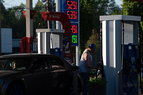 A sign displays gasoline prices as a person uses a fuel pump at a Mobil gas station on Wednesday, April 29, 2026, in Gresham, Ore.