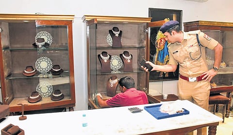 Police personnel inspect the PMJ Jewellery showroom in Karimnagar after a group of five burglars decamped with gold on Sunday morning.