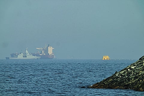 An Emirati patrol boat, left, is near a tanker anchored in the Gulf of Oman near the Strait of Hormuz, as seen from a coastal road near Khor Fakkan, United Arab Emirates, Friday, May 1, 2026.