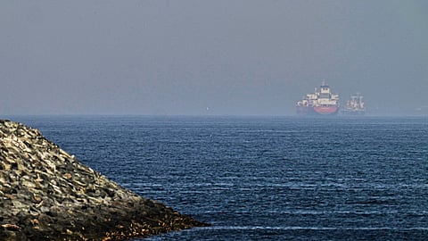 Cargo ships are seen at sea near the Strait of Hormuz, as viewed from a rocky shoreline near Khor Fakkan, United Arab Emirates, Friday, May 1, 2026.