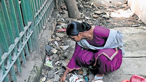 A shelter inhabitant shows the mouth of the pipe from where she collects her daily drinking water supply.