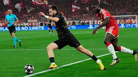 PSG's Khvicha Kvaratskhelia, left, runs with the ball as Bayern's Dayot Upamecano tries to stop him during the Champions League semifinal second leg soccer match between Bayern Munich and Paris Saint Germain in Munich, Germany, Wednesday, May 6, 2026.