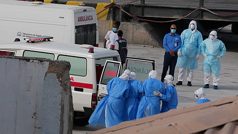 Health workers in protective gear evacuate patients from the MV Hondius cruise ship into an ambulance at a port in Praia, Cape Verde, Wednesday, May 6, 2026.