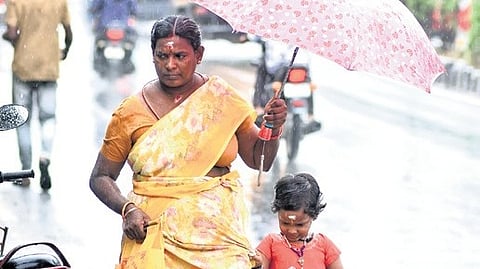 People walking in rain at Kolapakkam near Vandalur.
