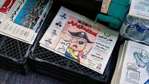 The front page of the Sunday, May 10, 2026, edition of the Iranian newspaper Jamejam is seen with a cartoon satirizing the US President Donald Trump that asks, "Open the Strait of Hormuz", on a newsstand in northern Tehran, Iran, Sunday, May 10, 2026.