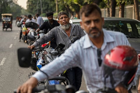 Tariqul Islam, a ride-share driver, waits in a long queue of petrol for his motorcycle in Dhaka, Bangladesh, Tuesday, April 23, 2026.