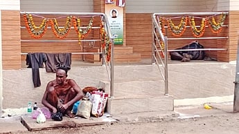 A mentally-unstable destitute man eats his food sitting on a drain slab along Mangalabag-Medical road.