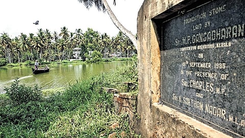 A country boat moves across the canal near the foundation stone laid in 1985 for the proposed bridge at Chenthilakkari in Panathura.