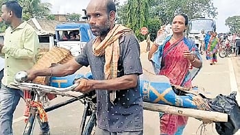 Surendra carrying his sister’s dead body on his bicycle to the police station.