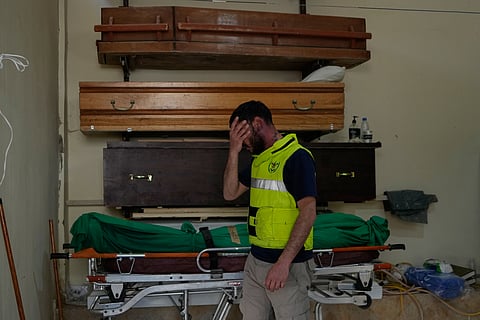 A civil defense worker reacts near the body of a person killed in an Israeli airstrike a day earlier in the village of Saksakieh, in Sidon, south Lebanon, Sunday, May 10, 2026.