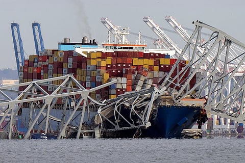 The cargo ship Dali is stuck under part of the Francis Scott Key Bridge after the ship hit the bridge, March 26, 2024, as seen from Pasadena, Md.