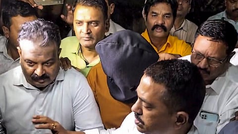 A CBI team takes custody of an accused arrested in connection with the alleged NEET-UG 2026 paper leak case, in Nashik, Tuesday, May 12, 2026.