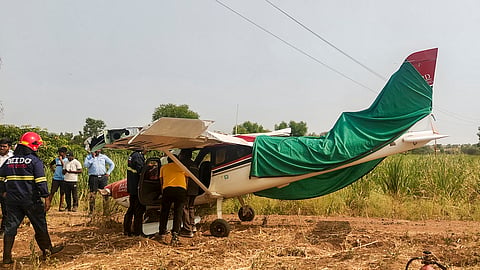Security officials conduct a rescue operation after a trainer aircraft operated by a private company crash-lands following a technical snag, at Baramati in Maharashtra's Pune district, Wednesday, May 13, 2026