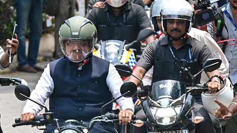 Maharashtra Chief Minister Devendra Fadnavis rides a two-wheeler, in view of Prime Minister Narendra Modi's appeal for austerity, at Vidhan Bhavan, in Mumbai, Thursday, May 14, 2026.