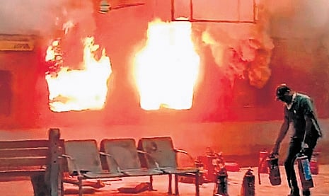 Firefighters douse flames in an AC coach at Nampally station on Friday.