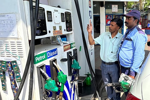 A commuter monitors the meter as an attendant refuels his vehicle at a filling station in New Delhi on Friday