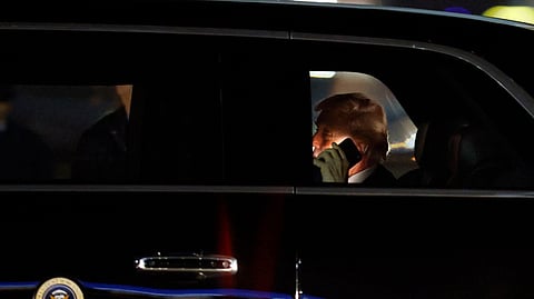 US President Donald Trump talks on his cell phone in his limousine, known as "The Beast", upon his arrival at Joint Base Andrews, Md.