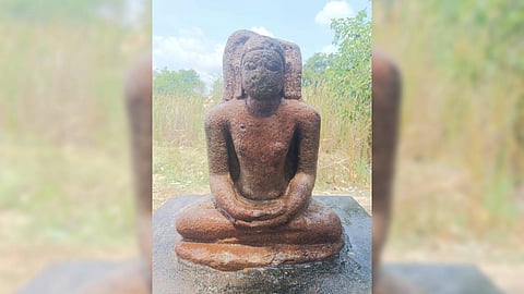 The statue depicts Buddha in a meditative posture, with elongated ears and a halo.