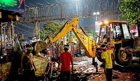 Civic workers carry out a demolition drive to remove allegedly illegal shops near the Howrah Railway Station area, West Bengal past midnight on May 17, 2026.