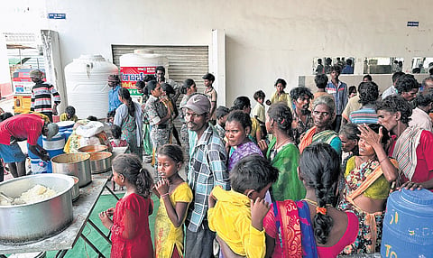 Rescued brick kiln labourers queuing for lunch under security (above), and one of the makeshift tents that housed them in Siddapur village, Nandipet mandal.
