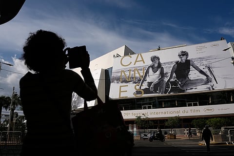 A person takes a photo outside the Palais des Festivals during preparations for the 79th international film festival, Cannes, southern France, Monday, May 11, 2026.